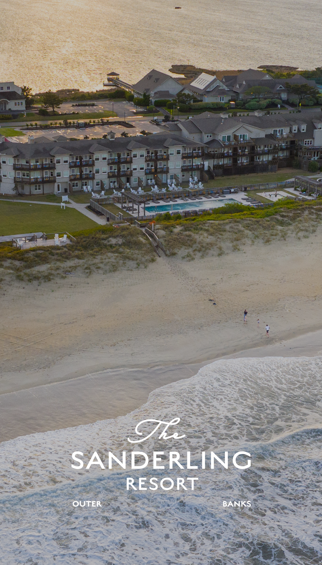 a beach with buildings and a pool