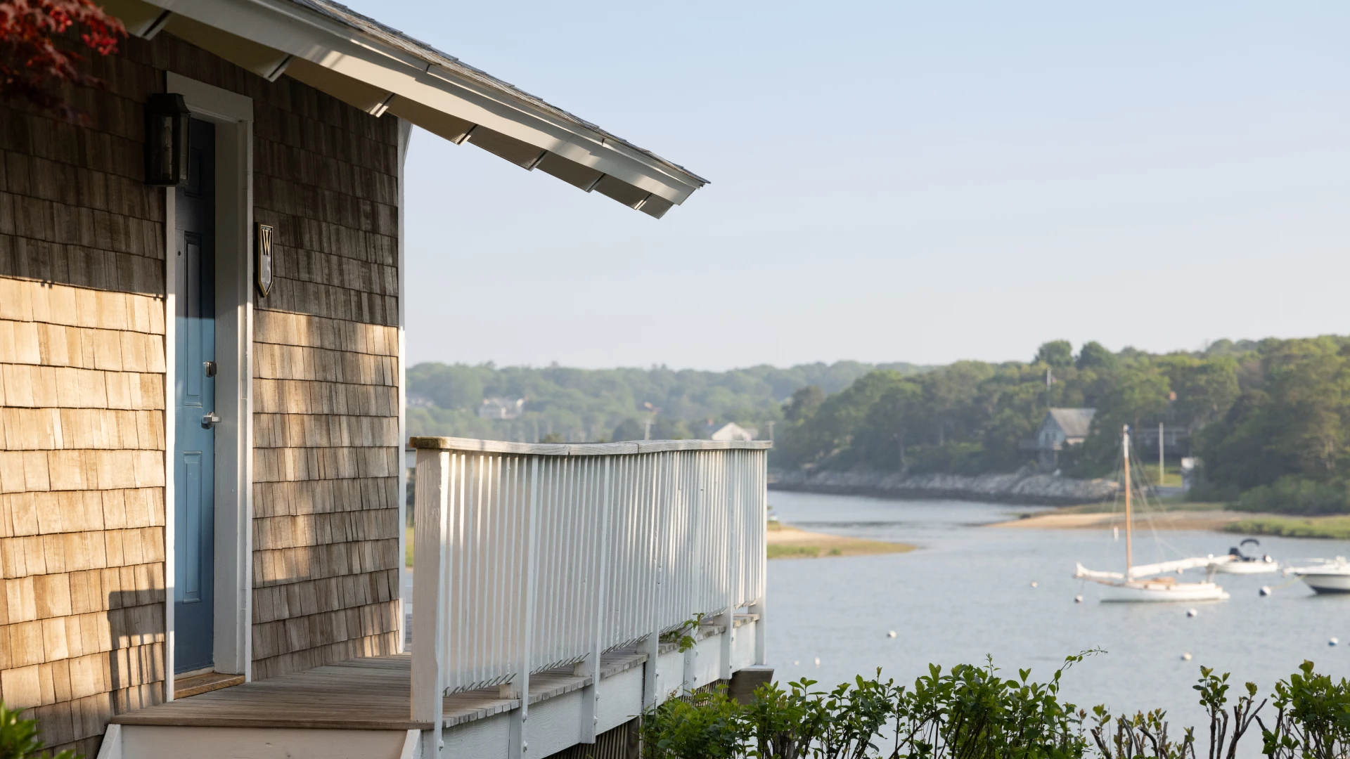 a deck with a white railing overlooking a body of water