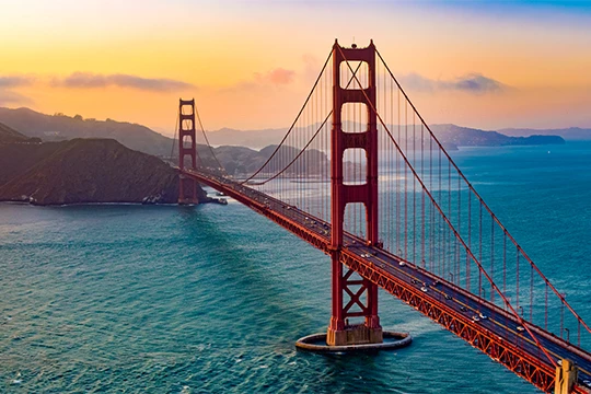 a large red bridge over water with Golden Gate Bridge in the background