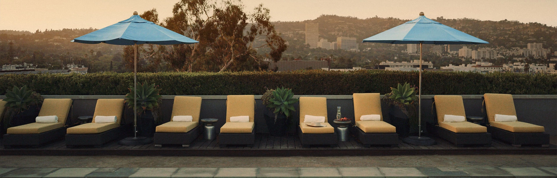 a view of yellow pool chairs and blue umbrellas at an outdoor pool