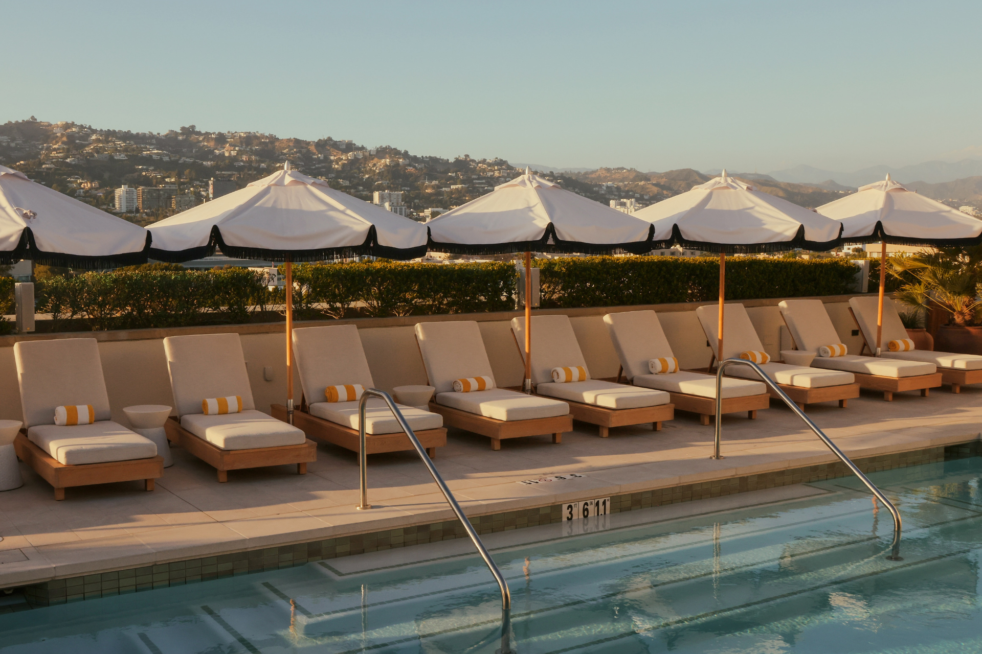a pool with umbrellas and lounge chairs