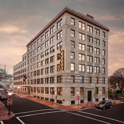 a building with a street and cars parked on the side
