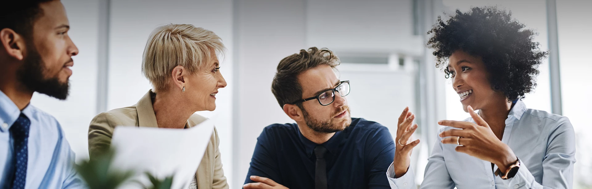 a group of people listening to a woman talk at a meeting