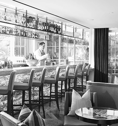bartender making a drink behind an elegant bar