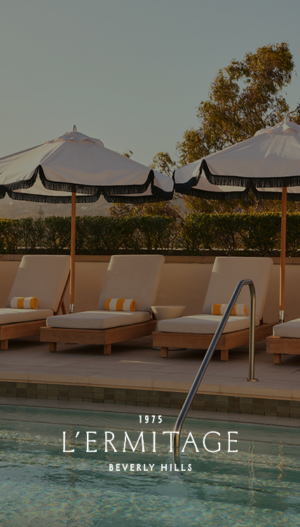 a group of lounge chairs and umbrellas by a pool