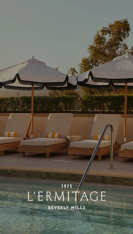 a group of lounge chairs and umbrellas by a pool