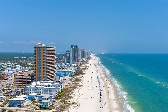 a beach with buildings and a body of water