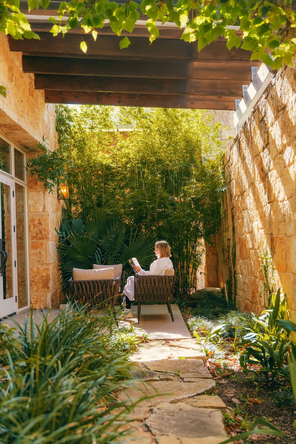 a woman sitting on a chair in a courtyard
