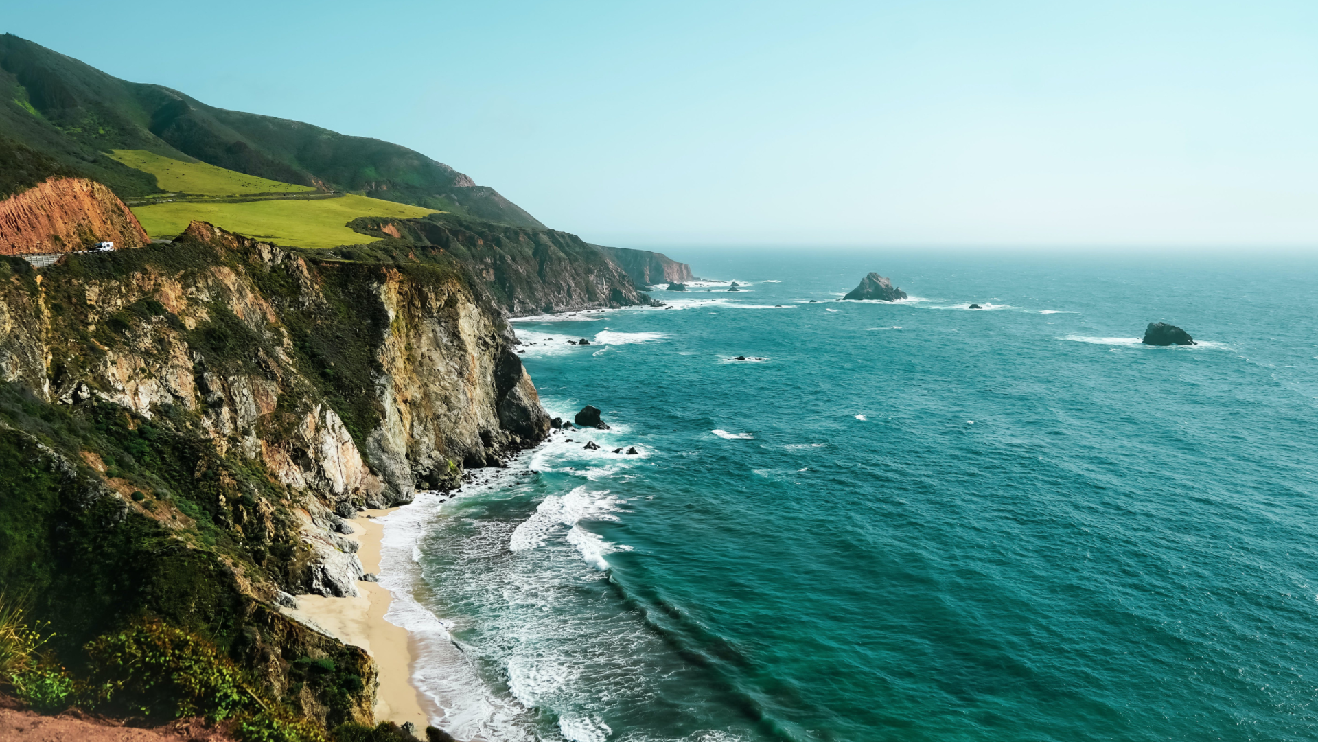 a beach with a cliff and water