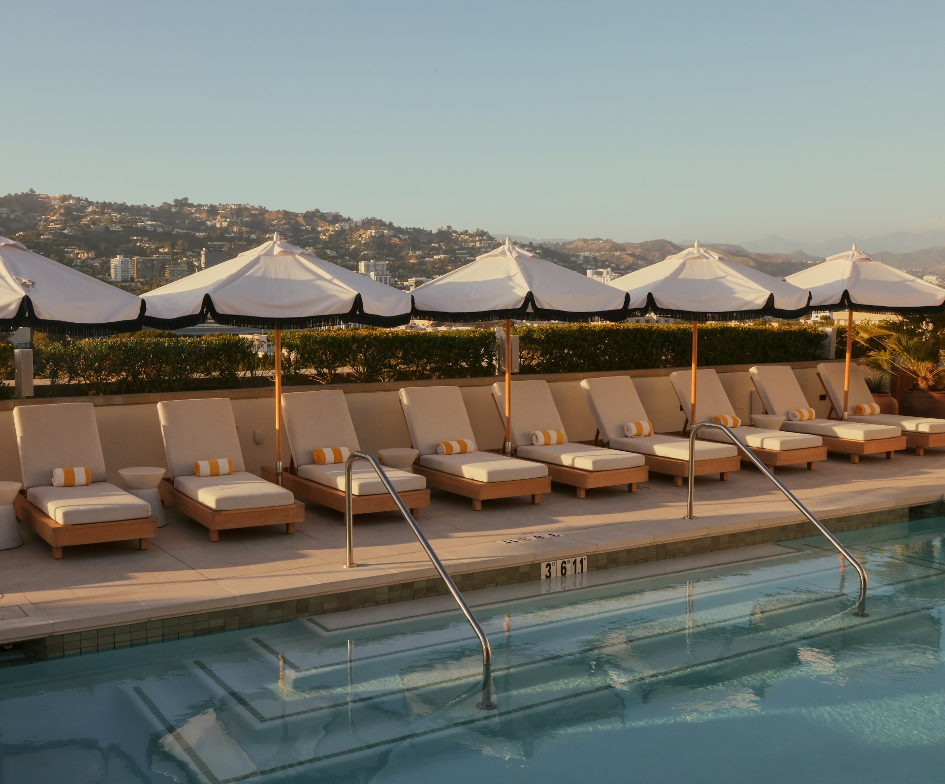 a pool with umbrellas and lounge chairs