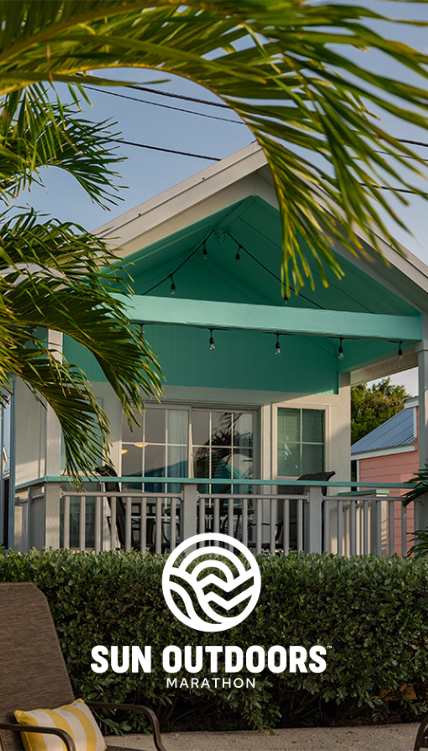 a house with a white railing and palm trees