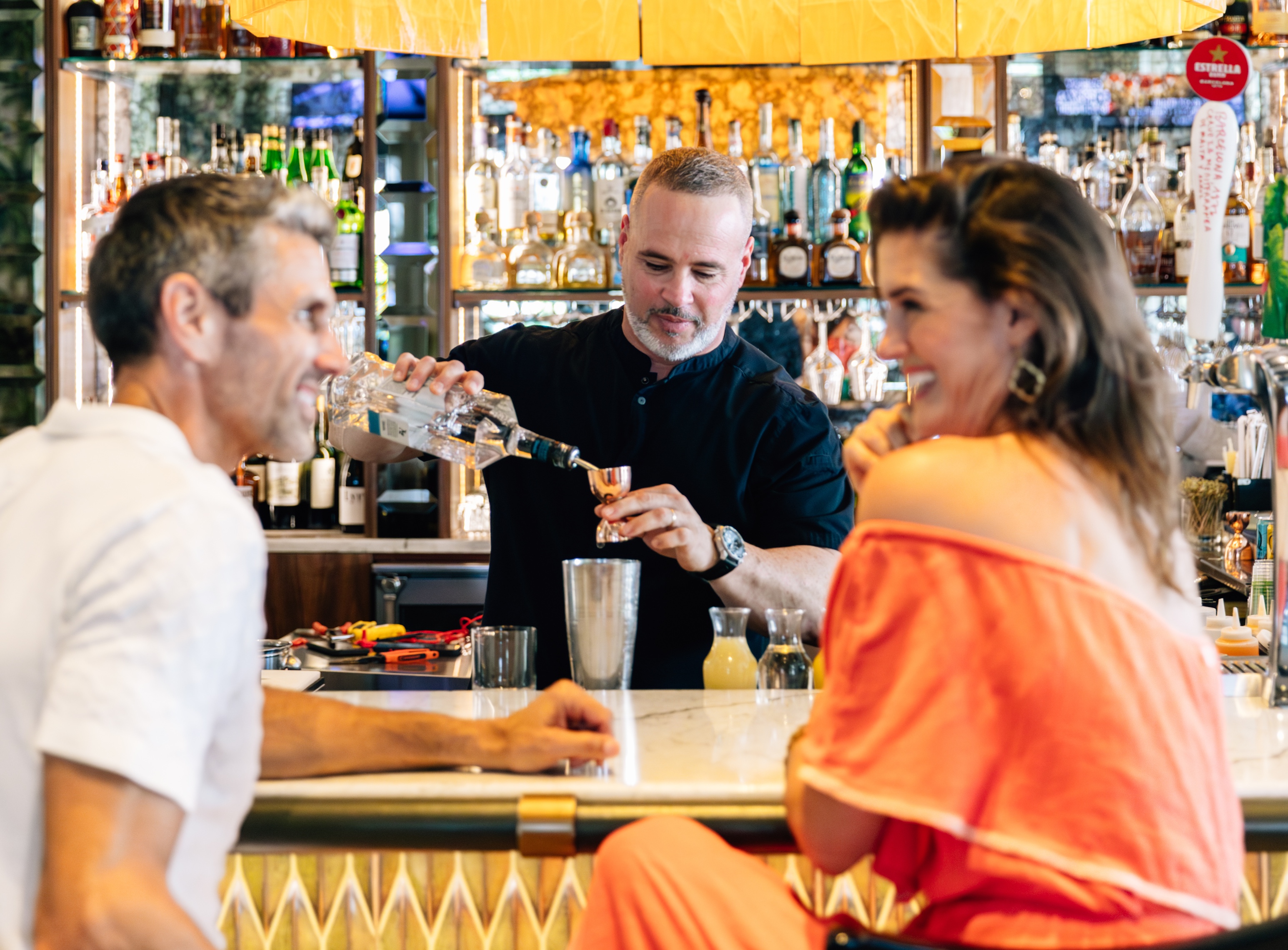 a man pouring a drink into a glass