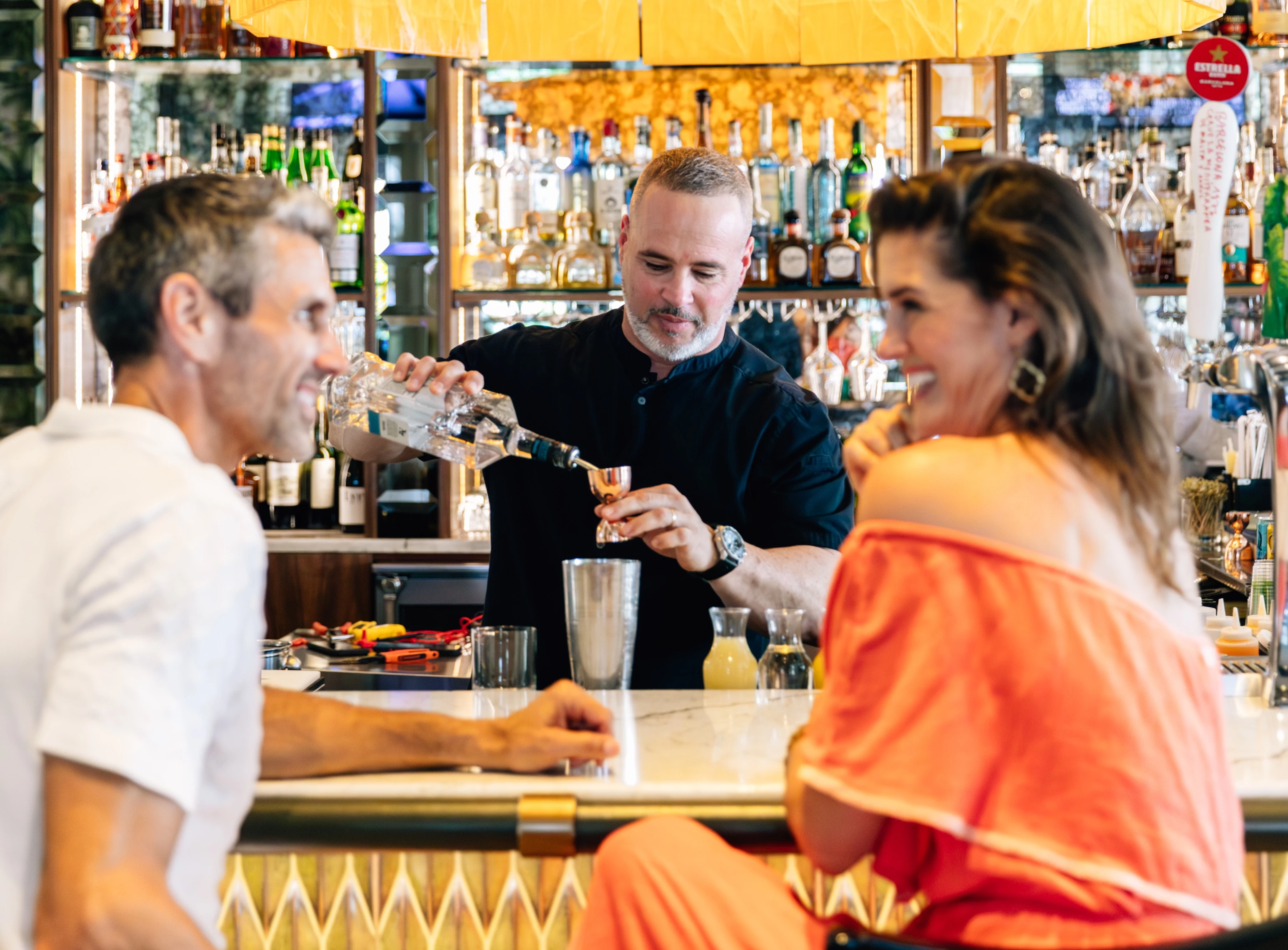 a man pouring a drink into a glass