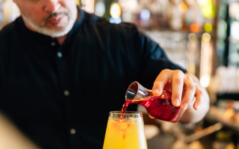 a man pouring a drink into a glass
