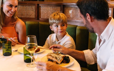 a man and boy sitting at a table with food