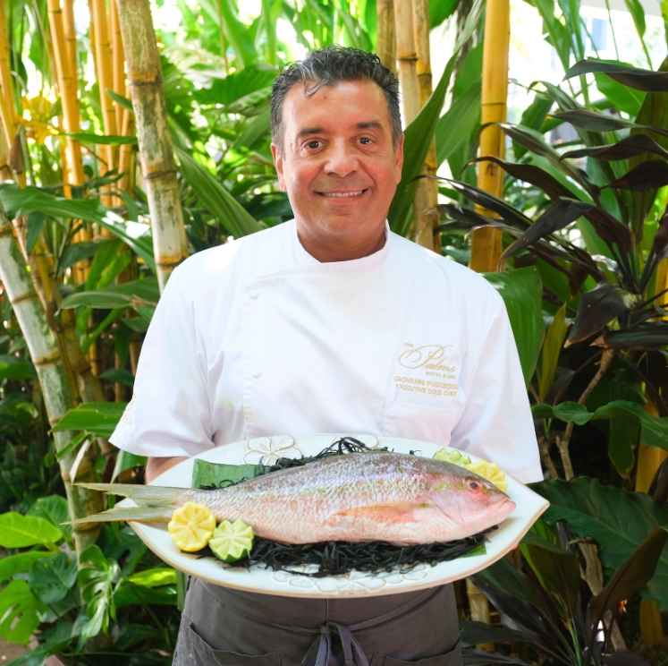 a man holding a plate of fish