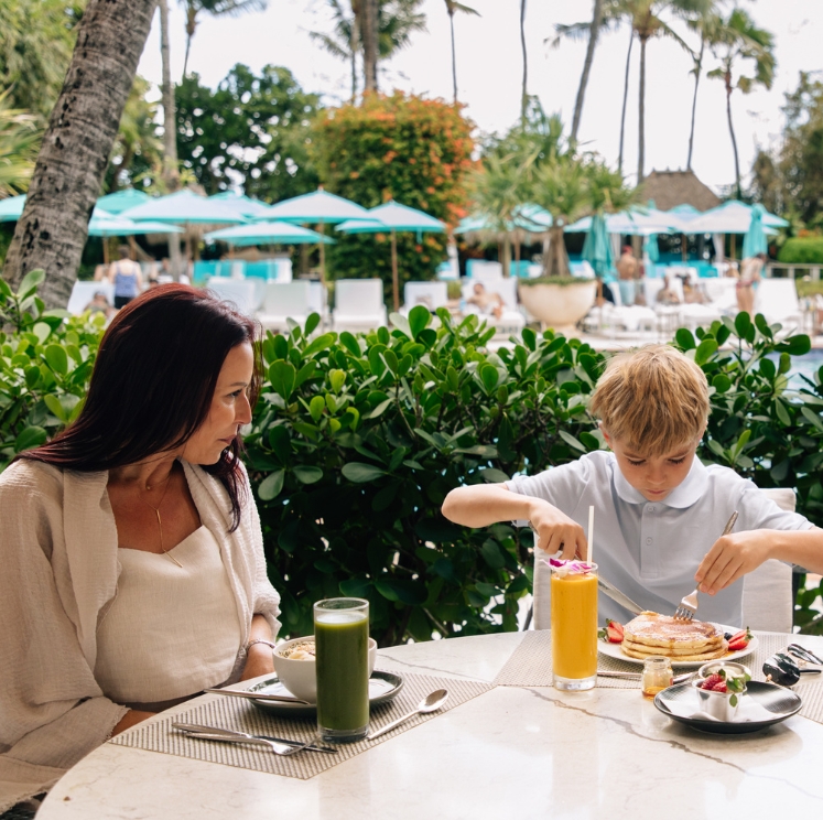 a woman and boy eating at a table