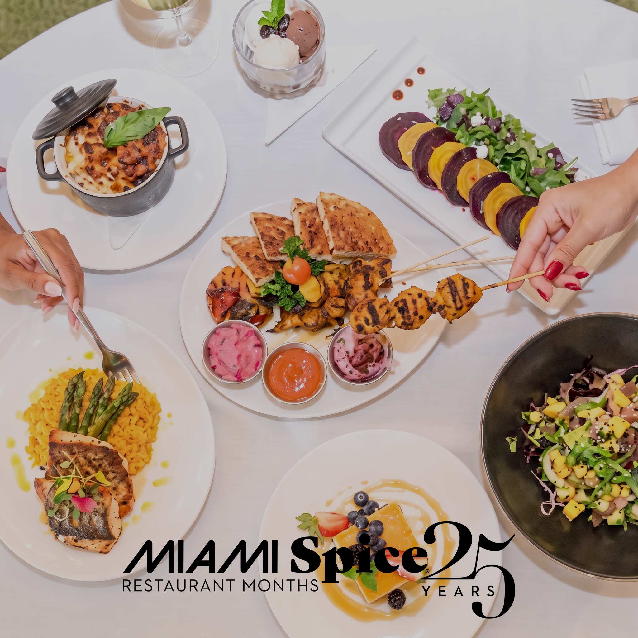 a table with plates of food and a person holding a skewer