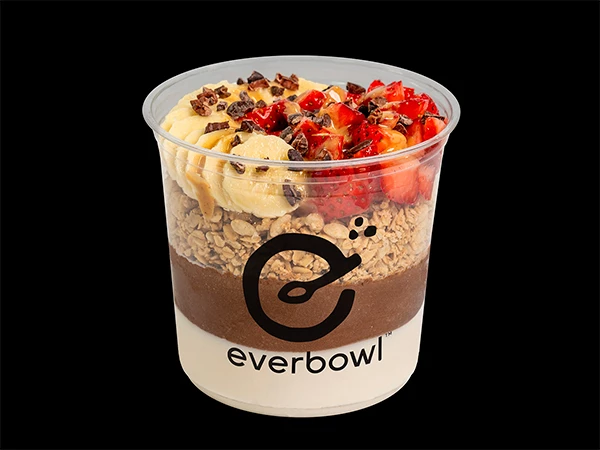 a cup of food with strawberries and chocolate chips