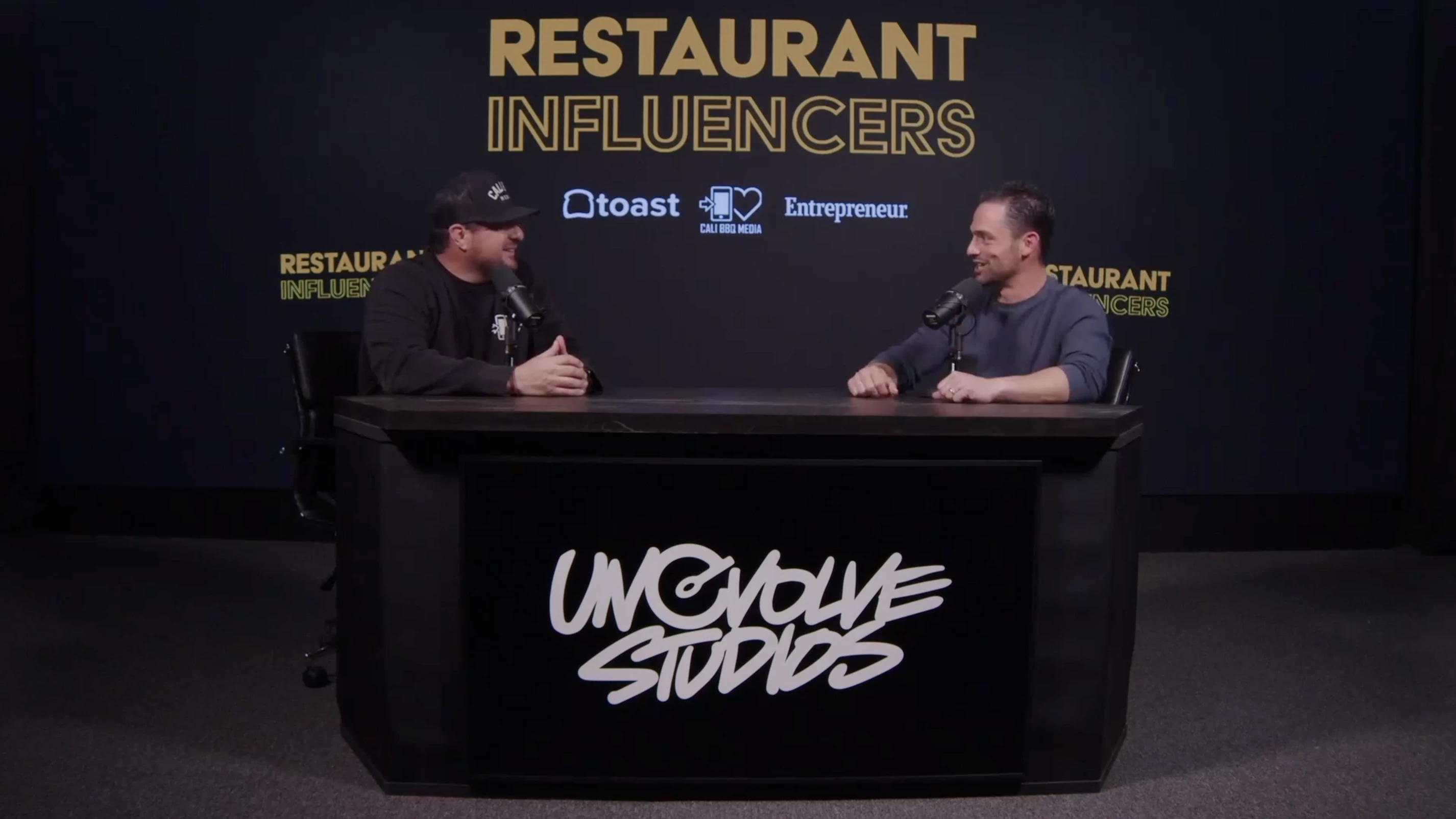 two men talking to each other on a podcast