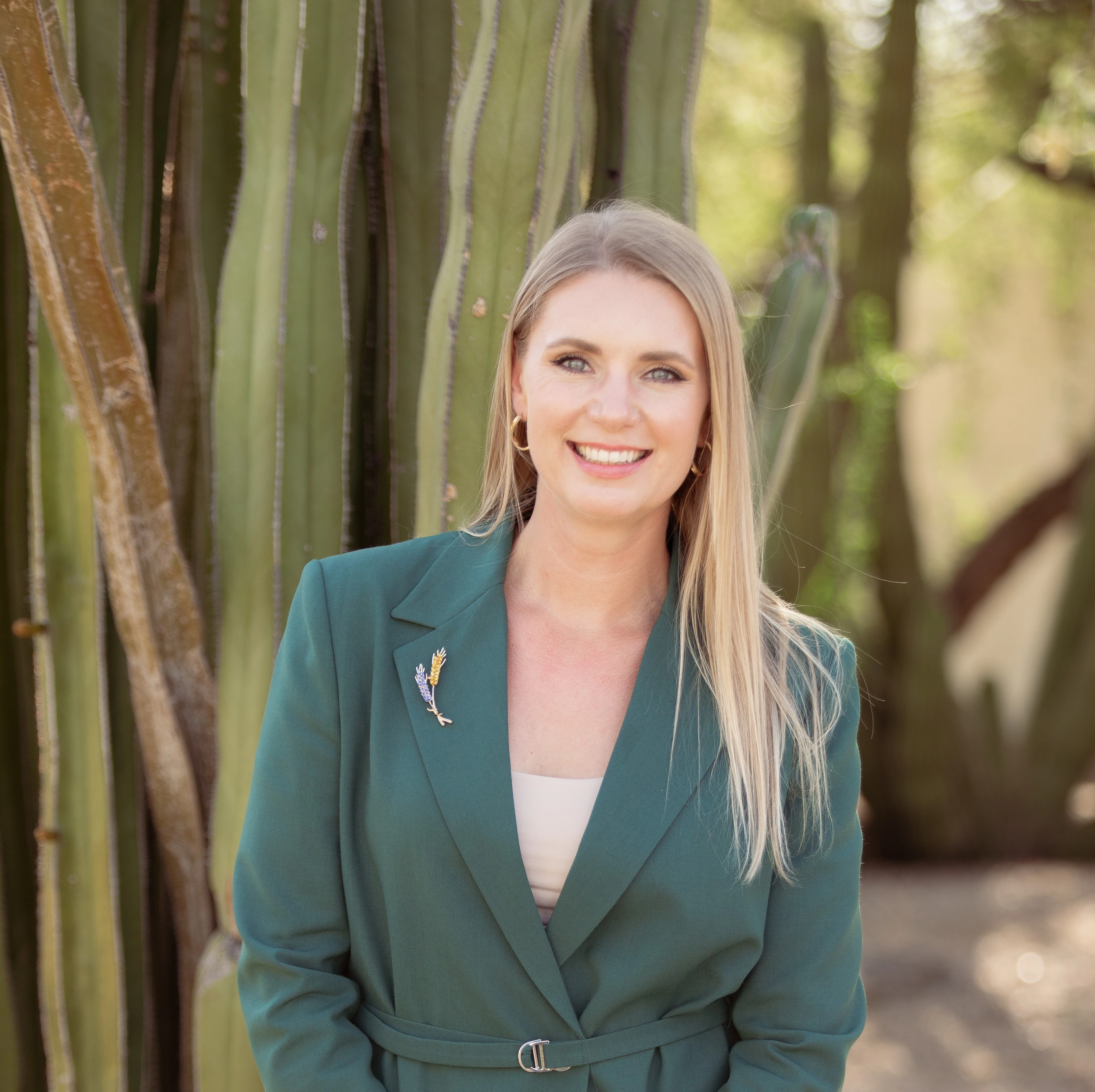 a woman smiling in front of a cactus