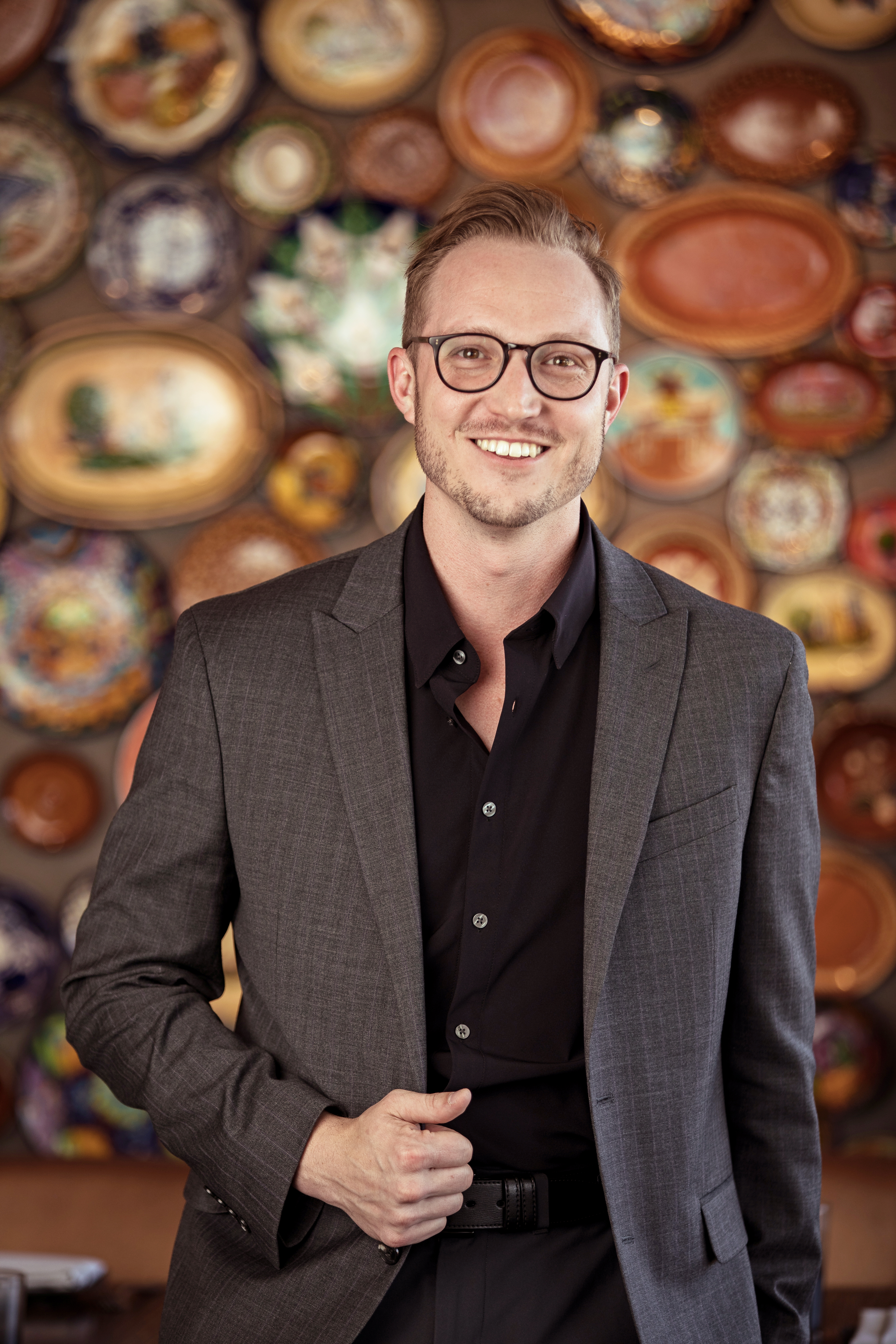 a man wearing a suit while smiling and posing