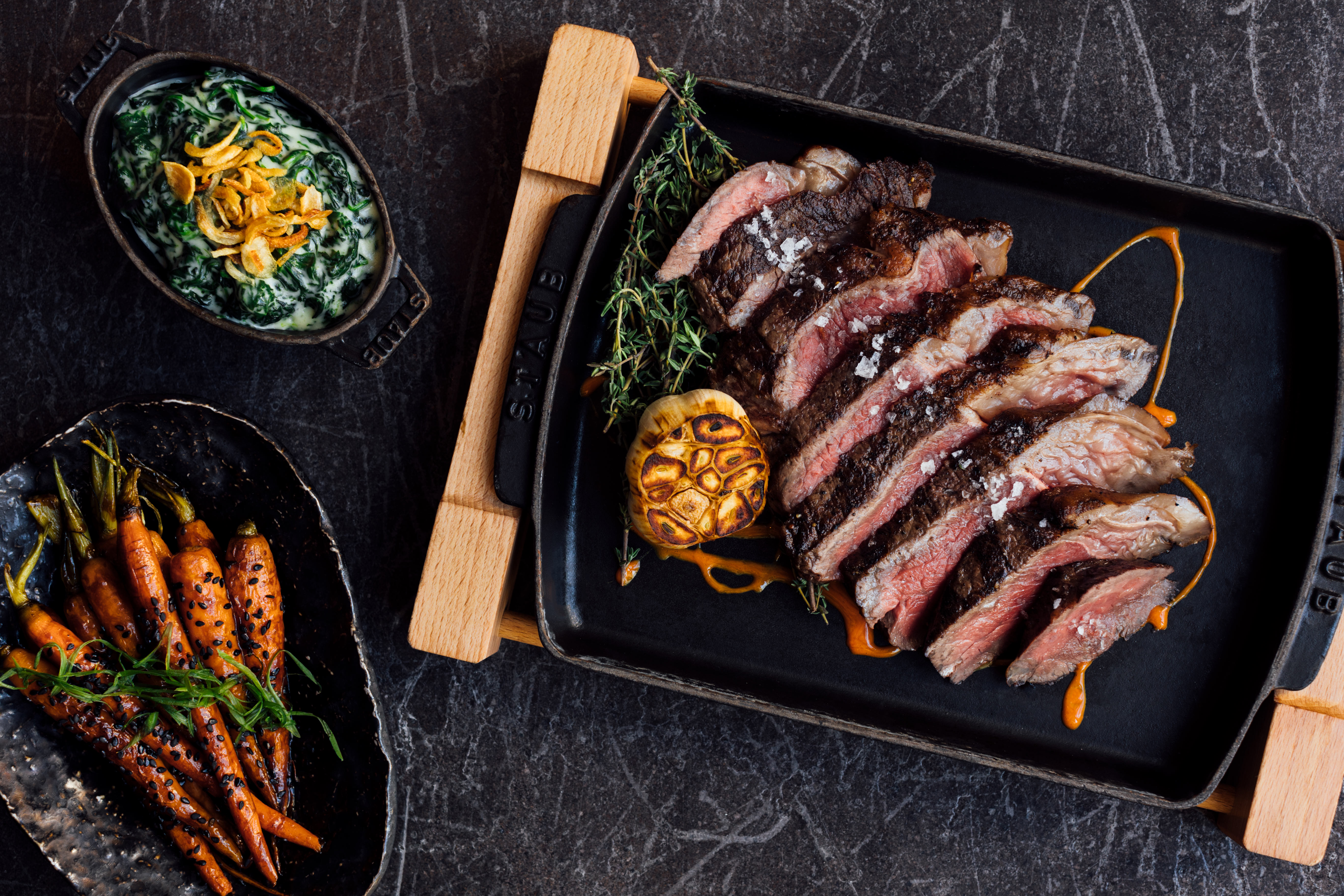 sliced steak, creamed spinach, and roasted carrots.