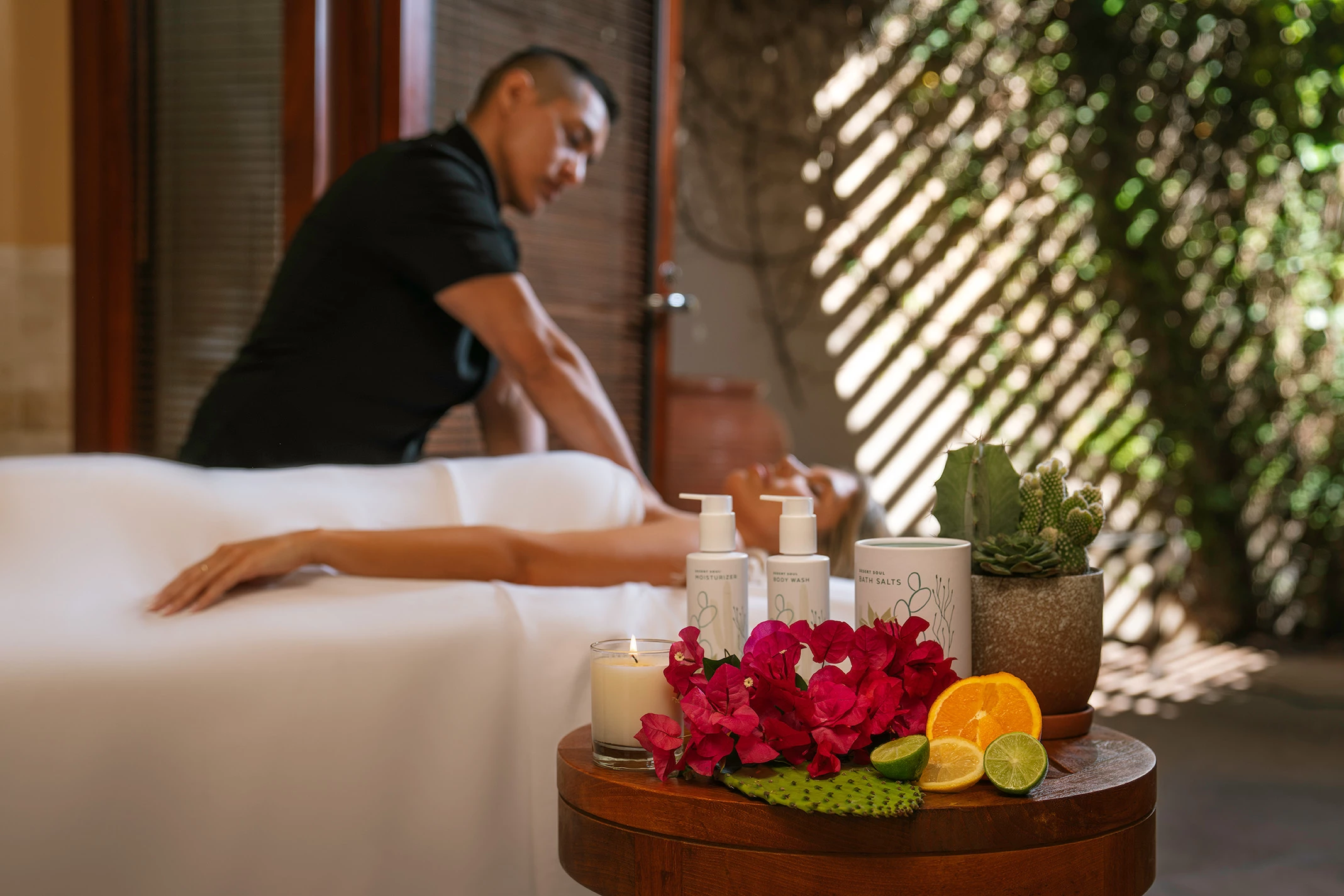 a woman lying on a massage table with a man in the background