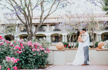 a man and woman kissing in front of flowers