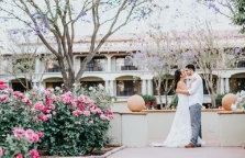 a man and woman kissing in front of flowers