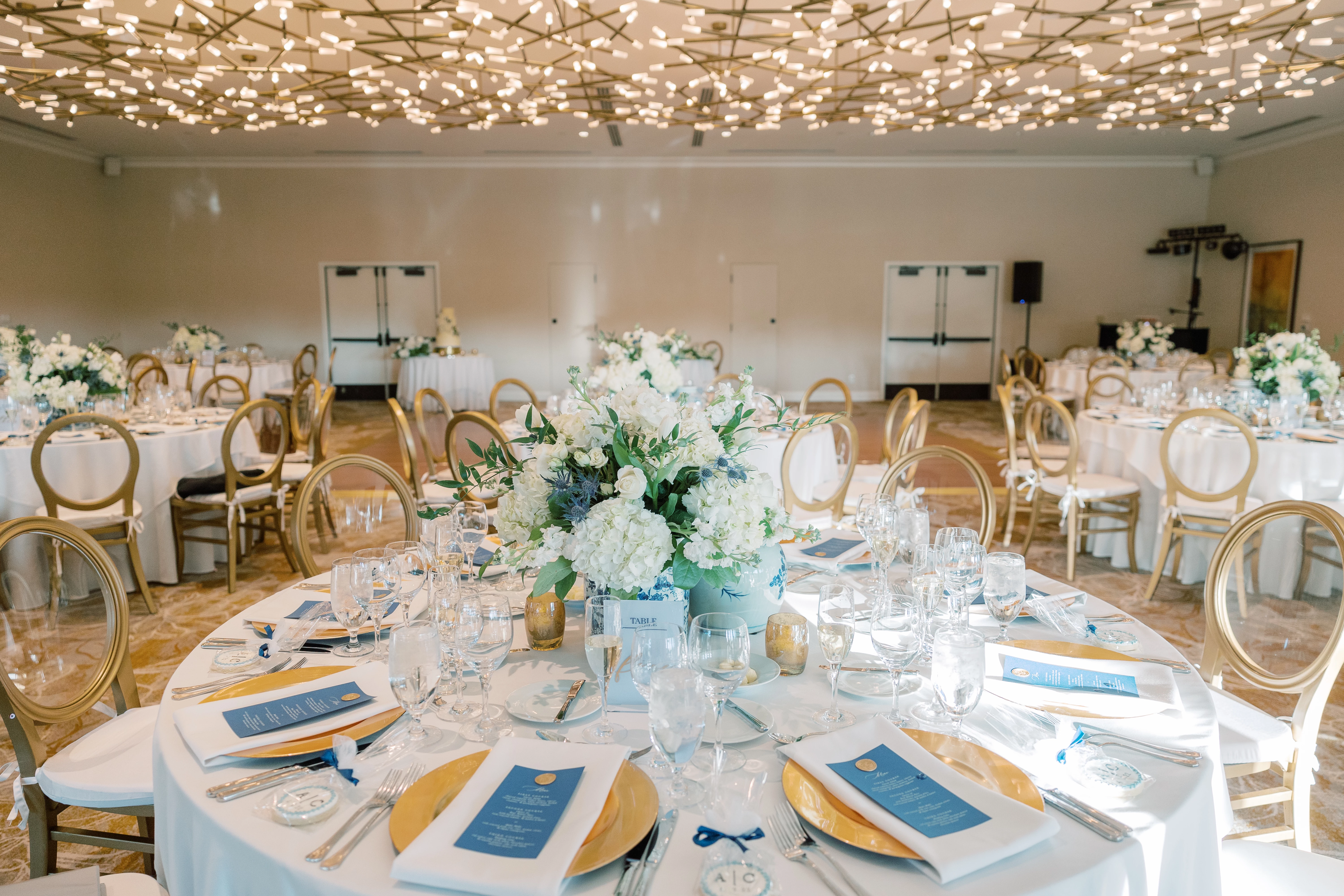 close up of round white tables set up for dinner and soft lighting from above