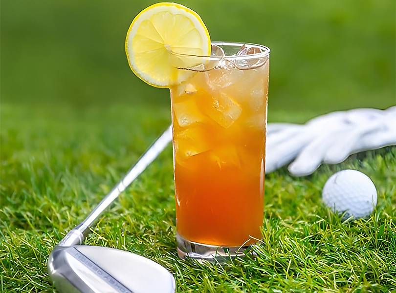 a glass of iced tea with a lemon slice on top of it