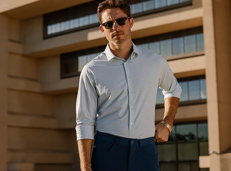 a man in sunglasses standing in front of a building