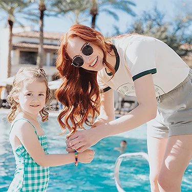 a woman and a girl by a pool