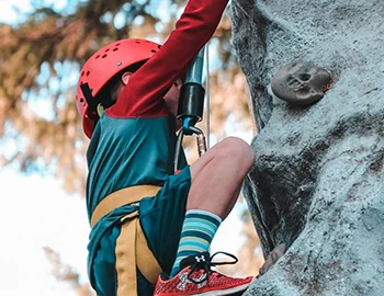 kid climbing on a rock climbing wall