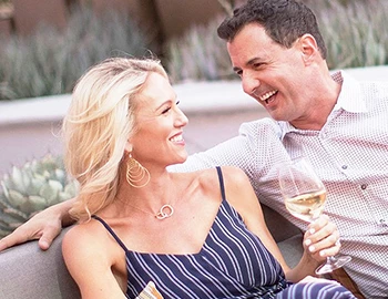 a smiling man and woman sitting outside