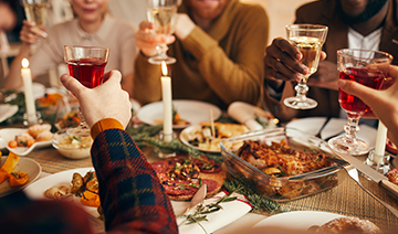 a family gathering at a holiday dinner with their glasses raised to cheers