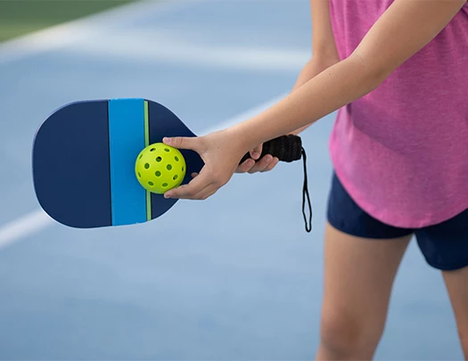 a person holding a paddle and a ball