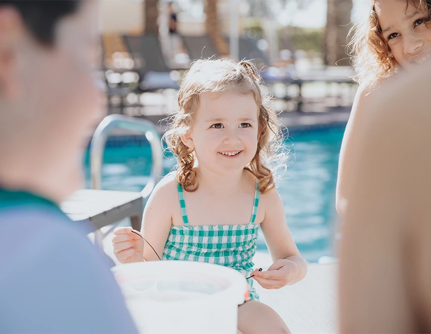 a girl sitting on a pool side