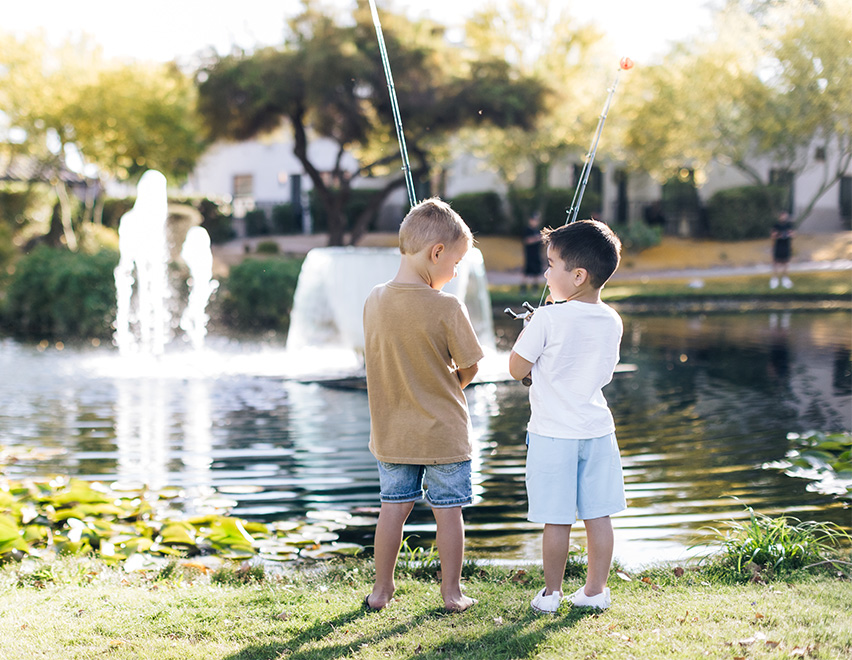 two boys standing in front of a fountain