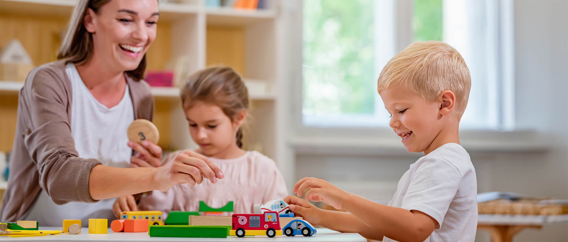 a boy and girl playing with toy cars
