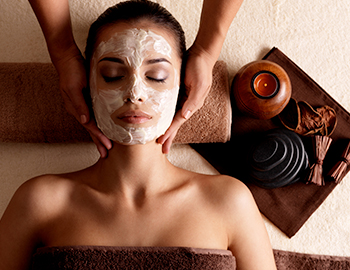 a woman laying down while getting a facial