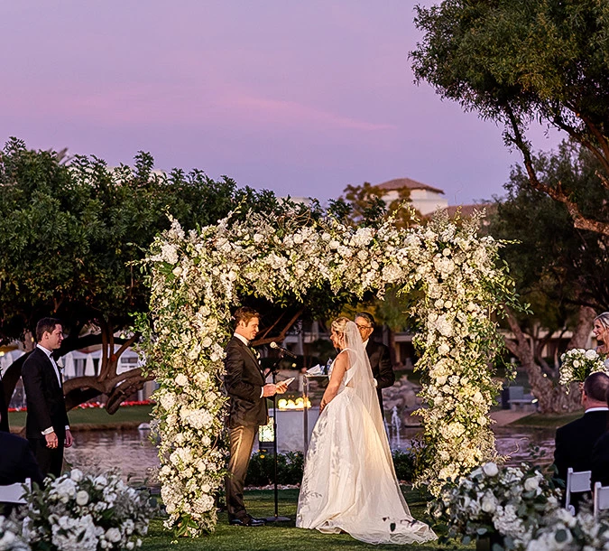 a bride and groom getting married at sunset