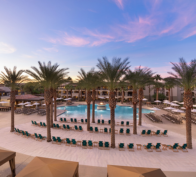 the lounge area next to the pool at dusk