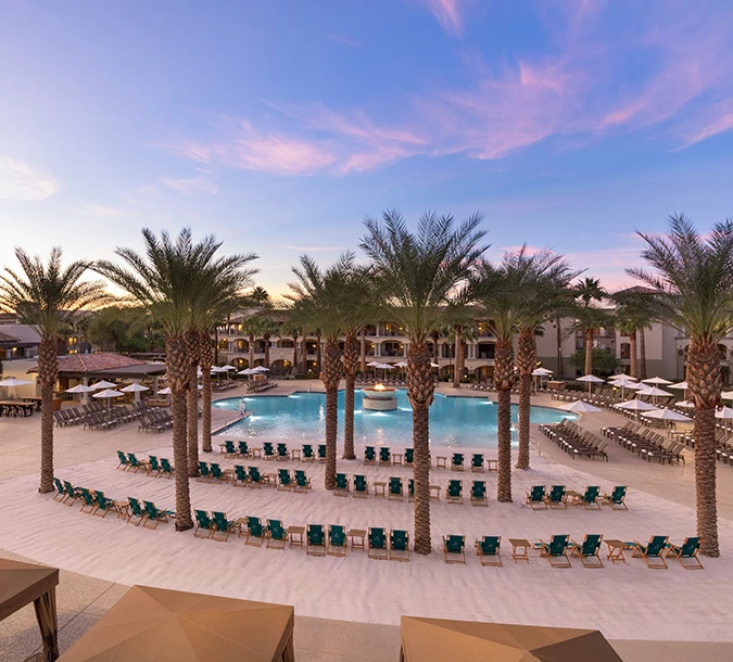 the lounge area next to the pool at dusk