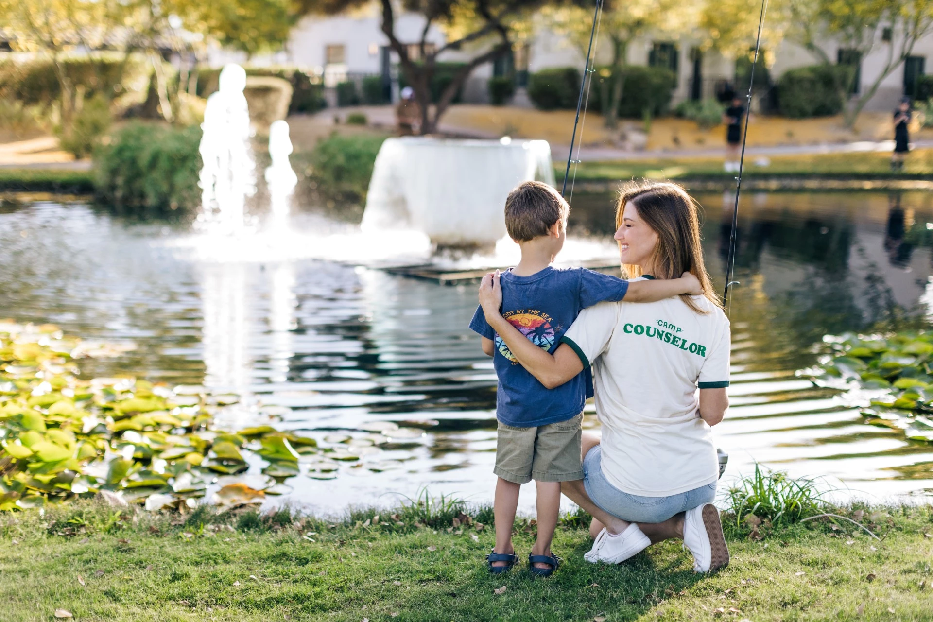 a woman and child fishing in a park
