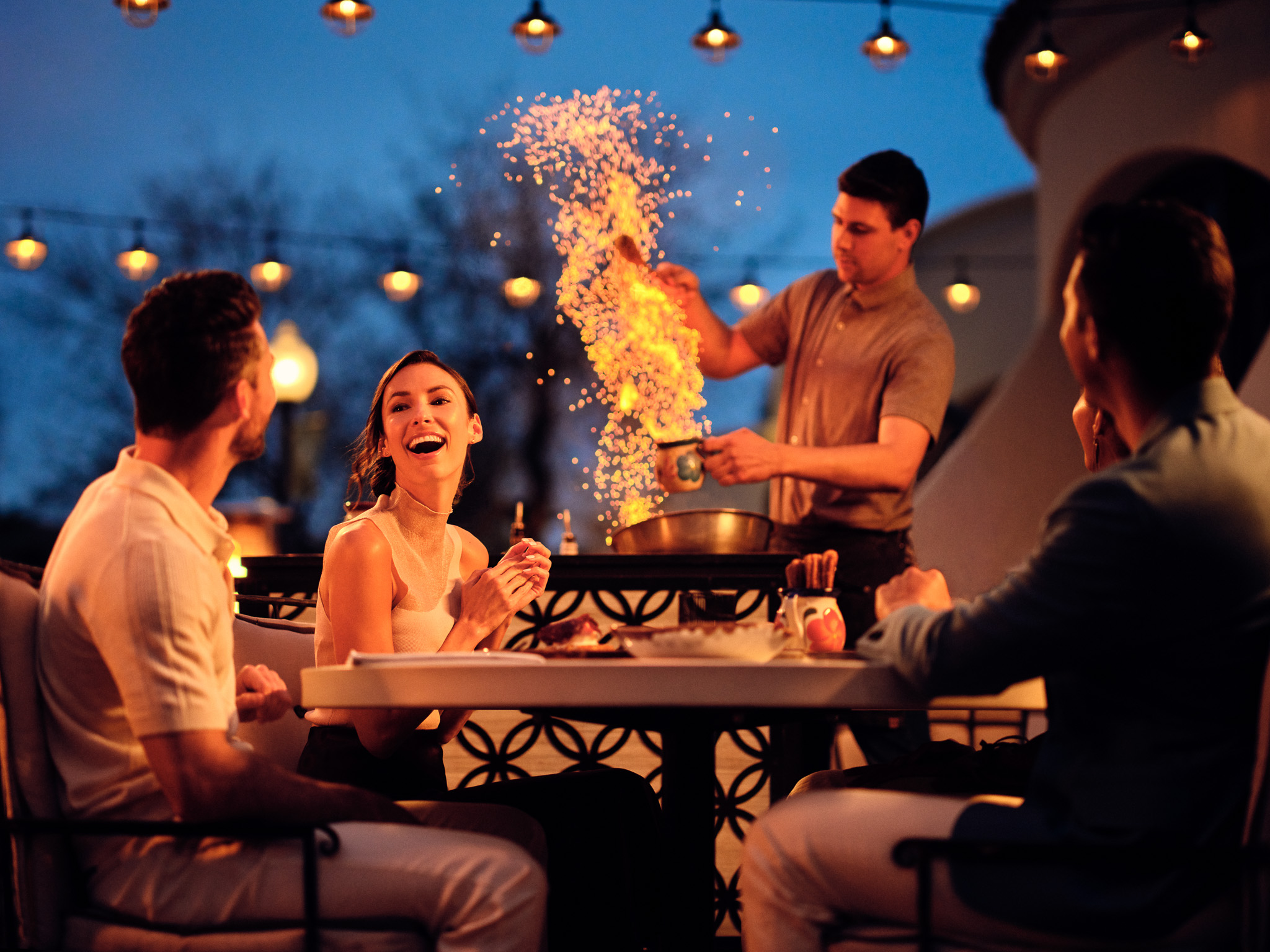 a group of people sitting around a table with food on it