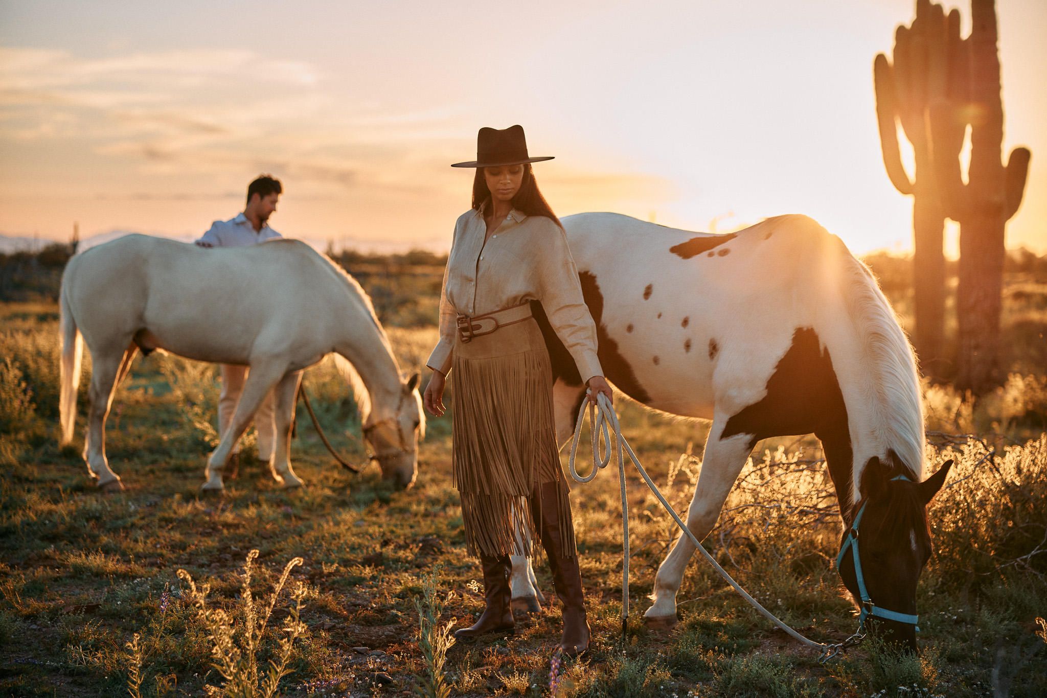 a person with a hat and a couple of horses