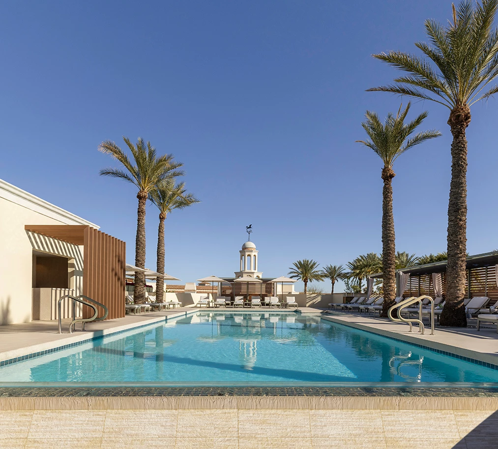 a pool with palm trees and a building with a dome on the roof