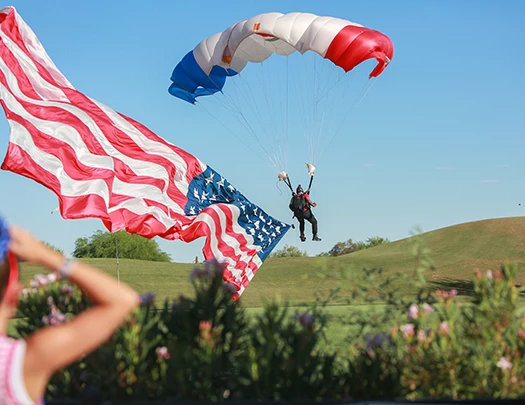 a person in the air with parachutes